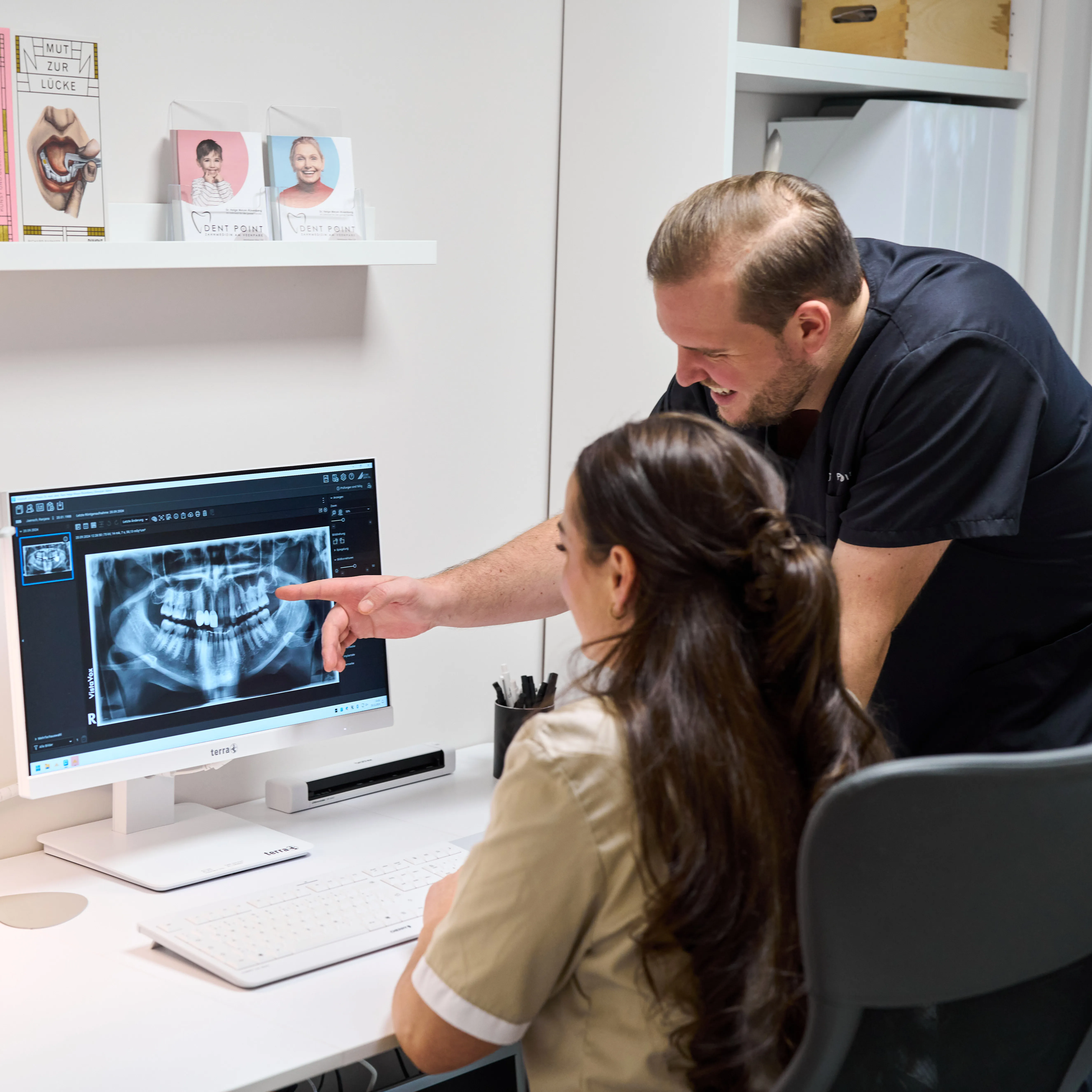 Zahnarzt Dr. Helge Meyer-Rüsenberg zeigt Röntgenbild am Monitor zur Diagnostik in der Zahnarztpraxis Dent Point Düsseldorf